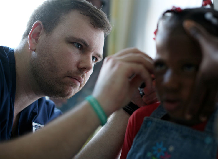 MD student inspects child's ear