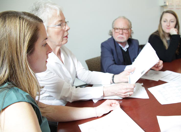 Four researchers sitting at a table reviewing information