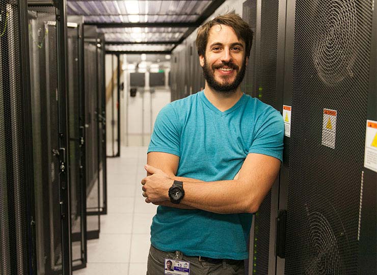 Image of male standing next to computer server