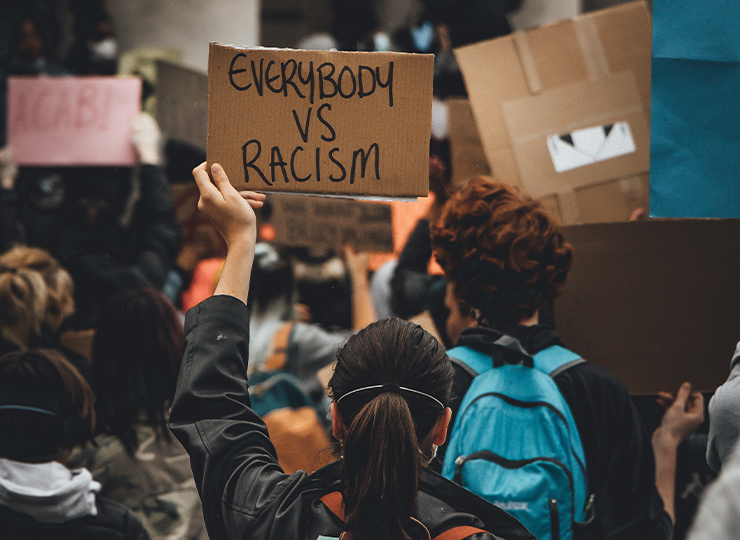 Woman holding up sign “Everbody vs Racism