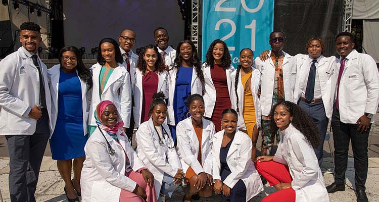 Medical students posing for photo in white coats.