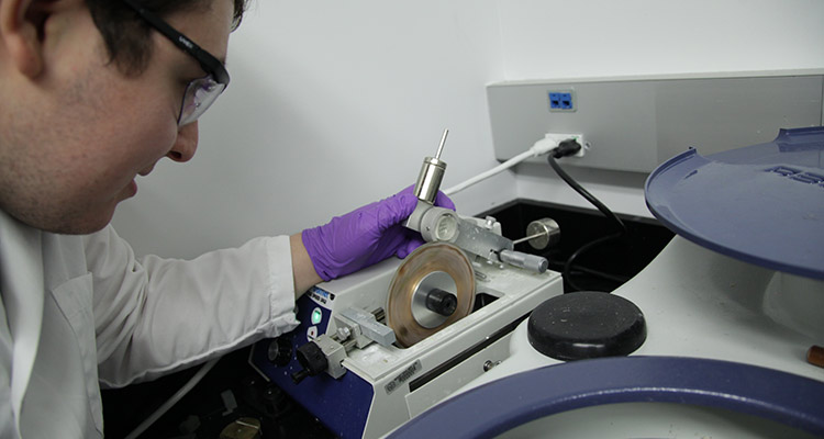 Researcher examines a laboratory mechanism
