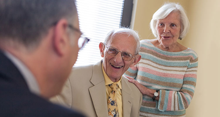 doctor talking to elderly patient and partner
